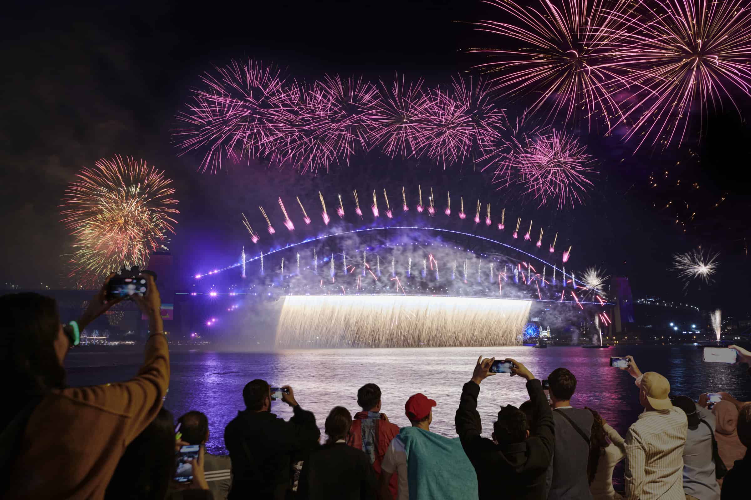 Crowds at the Opera House take photos of the Sydney new year fireworks