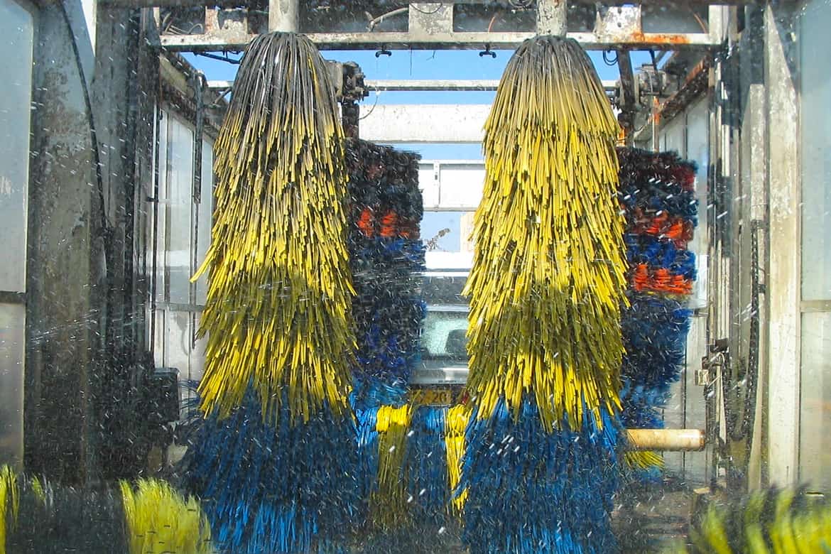 Yellow and blue brushes of a car wash in action